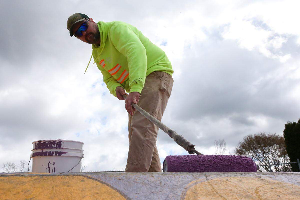 Todd Baginski, parks groundskeeper for the city of Sumner, paints over graffiti at the skate park in the Daffodil Valley Sports Complex on Wednesday, March 30.