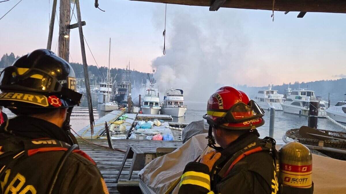 Firefighters respond to a fire on Bujacich Dock in Gig Harbor, Wash., as smoke billows from the burning boats on Saturday, Jan. 25, 2025.