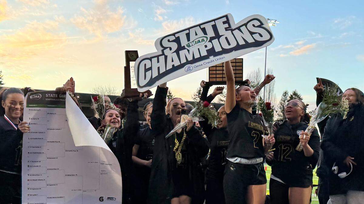 No. 1 Lincoln’s girls flag football team hoists the state championship trophy after beating No. 10 Seattle Prep, 21-14, in the 3A title game at Federal Way Memorial Field on Feb. 14, 2026, in Federal Way, Wash.
