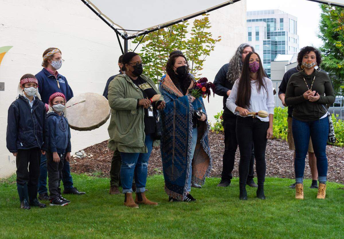 Members of the Puyallup Indian Tribe’s language department sing a traditional song led by Puyallup Language Department Director Amber Hayward, right, at the unveiling of a new art installation at the Alma Mater community hub in Tacoma Wednesday, Sept. 29. The piece acknowledges the traditional lands of the Tribe and was created in collaboration with the language department.