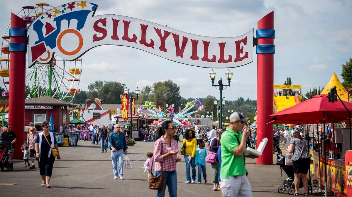 People walk through Sillyville at the Washington State Fair in Puyallup last fall. The fair is holding a job fair July 31.