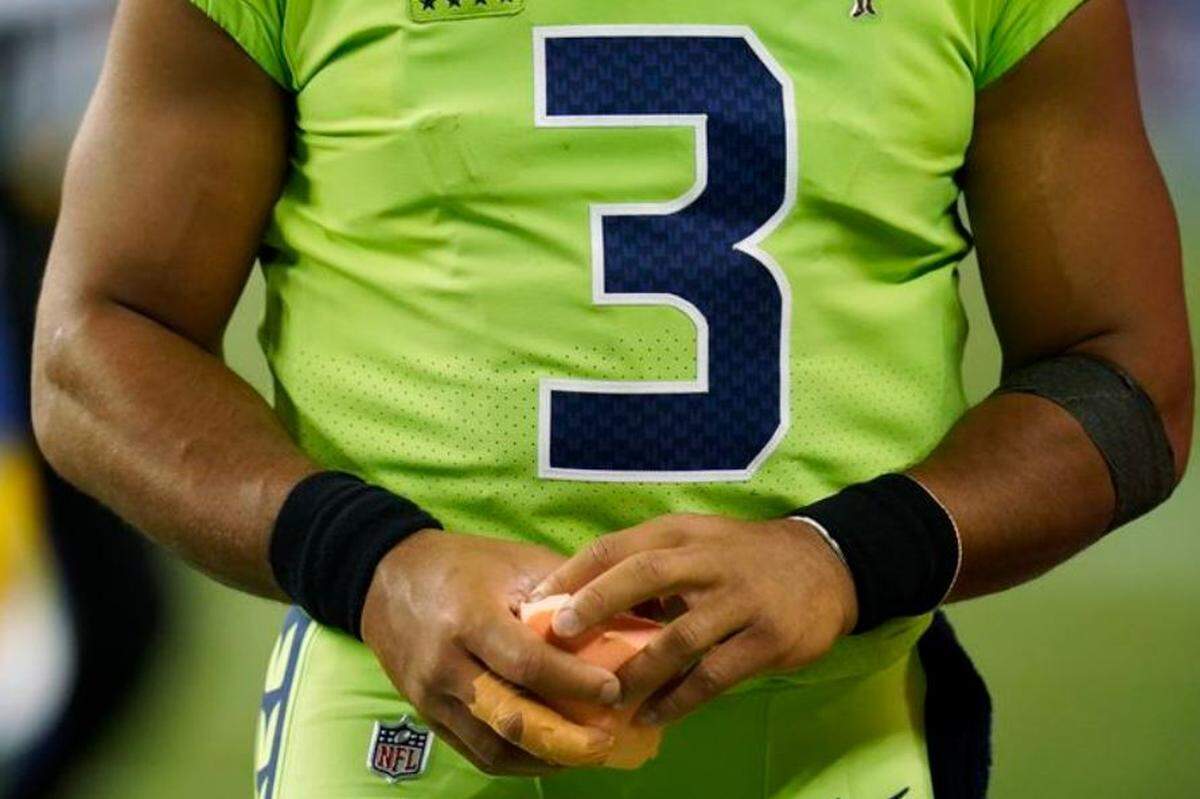 Russell Wilson holding his taped, dislocated finger on his throwing hand after injuring it during the Seahawks’ home loss to the Los Angeles Rams Thursday, Oct. 7, at Lumen Field in Seattle.