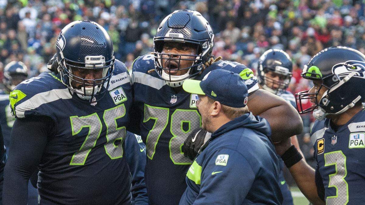 Seahawks guard D.J. Fluker (#78) exhales in pain as he’s helped off the field by fellow lineman Duane Brown. The Seattle Seahawks played the San Francisco 49ers in a NFL football game at CenturyLink Field in Seattle, Wash., on Sunday, Dec. 2, 2018.