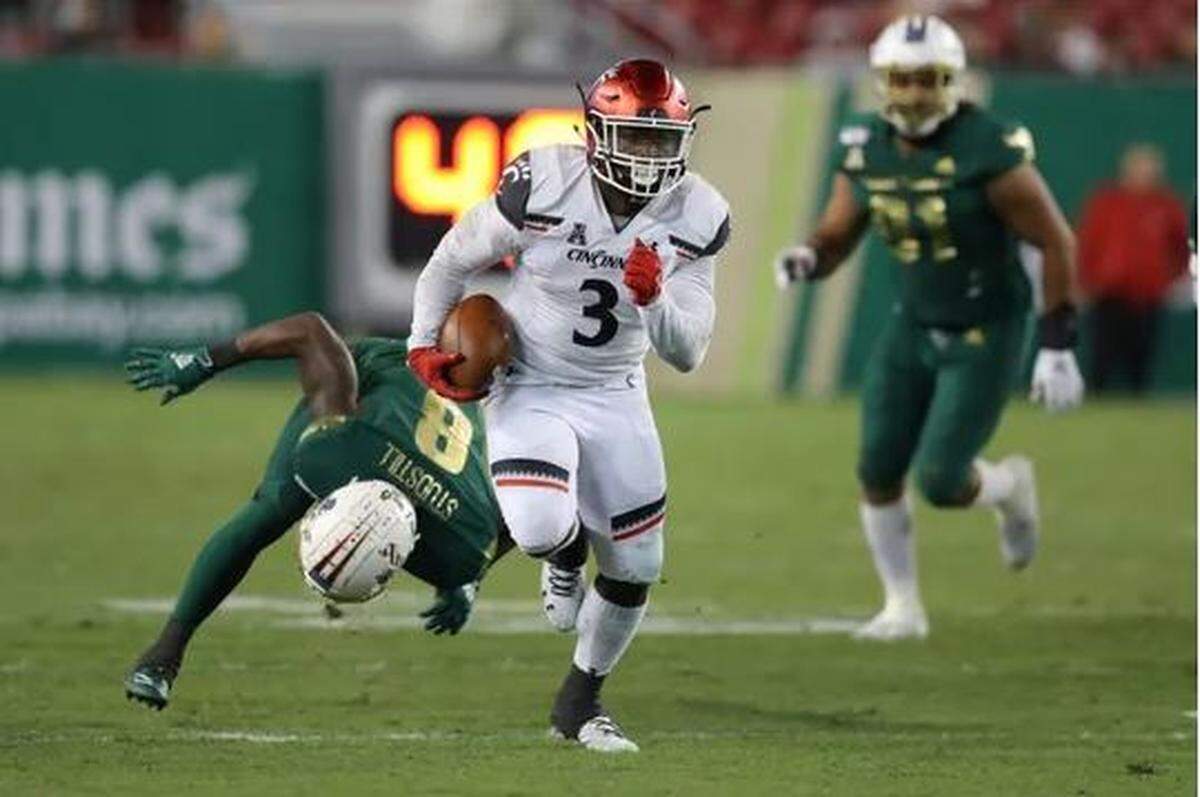 Michael “The Truck” Warren doing what he did often for the University of Cincinnati: running through tacklers. He’s 226 pounds.