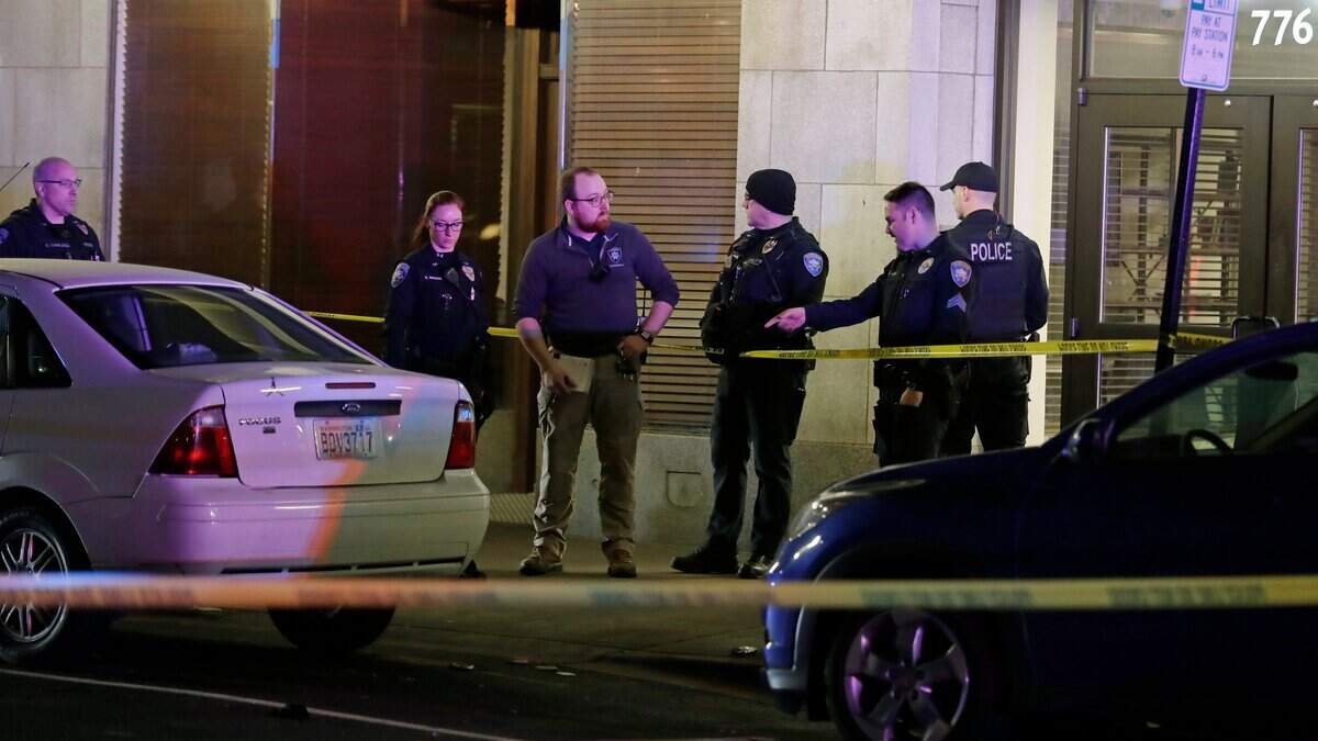 In this Friday, Dec. 13, 2019, photo, police officers investigate the scene after a Tacoma police officer was reportedly stabbed in downtown Tacoma, Wash. The officer was treated at a hospital, and the man who stabbed the officer was arrested. (AP Photo/Ted S. Warren)