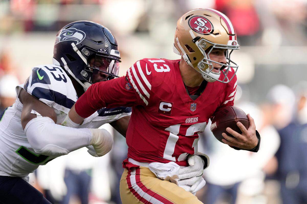 San Francisco 49ers quarterback Brock Purdy (13) runs against Seattle Seahawks linebacker Boye Mafe (53) during the first half of an NFL football game in Santa Clara, Calif., Sunday, Dec. 10, 2023. (AP Photo/Godofredo A. Vásquez)