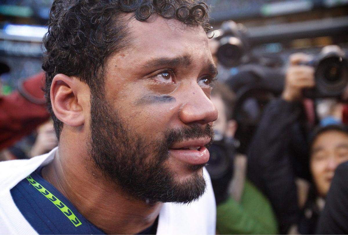 Seahawks quarterback Russell Wilson sheds tears after the Seahawks come-from-behind overtime victory over the Green Bay Packers during the NFL Division Championship game at CenturyLink Field in Seattle on Sunday, Jan. 18, 2015.