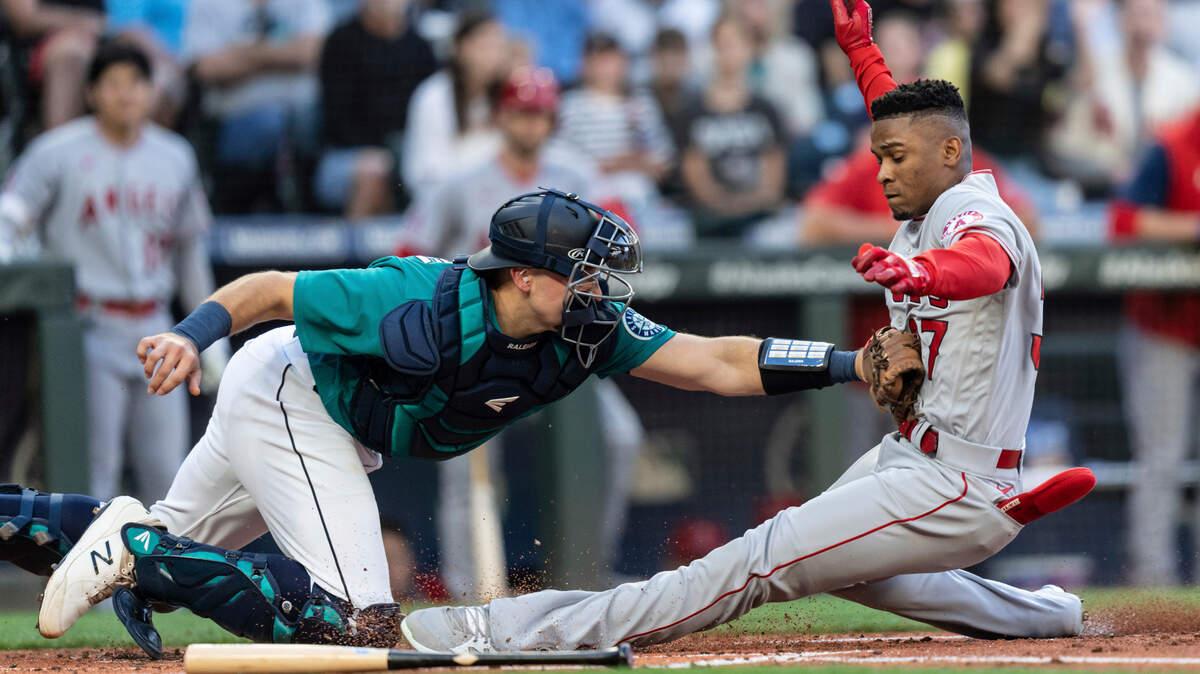 Seattle Mariners catcher Cal Raleigh tags out Los Angeles Angels’ Magneuris Sierra at home plate after Sierra attempted to stretch a triple to an inside-the-park home run during the second inning of a baseball game Friday, Aug. 5, 2022, in Seattle. (AP Photo/Stephen Brashear)