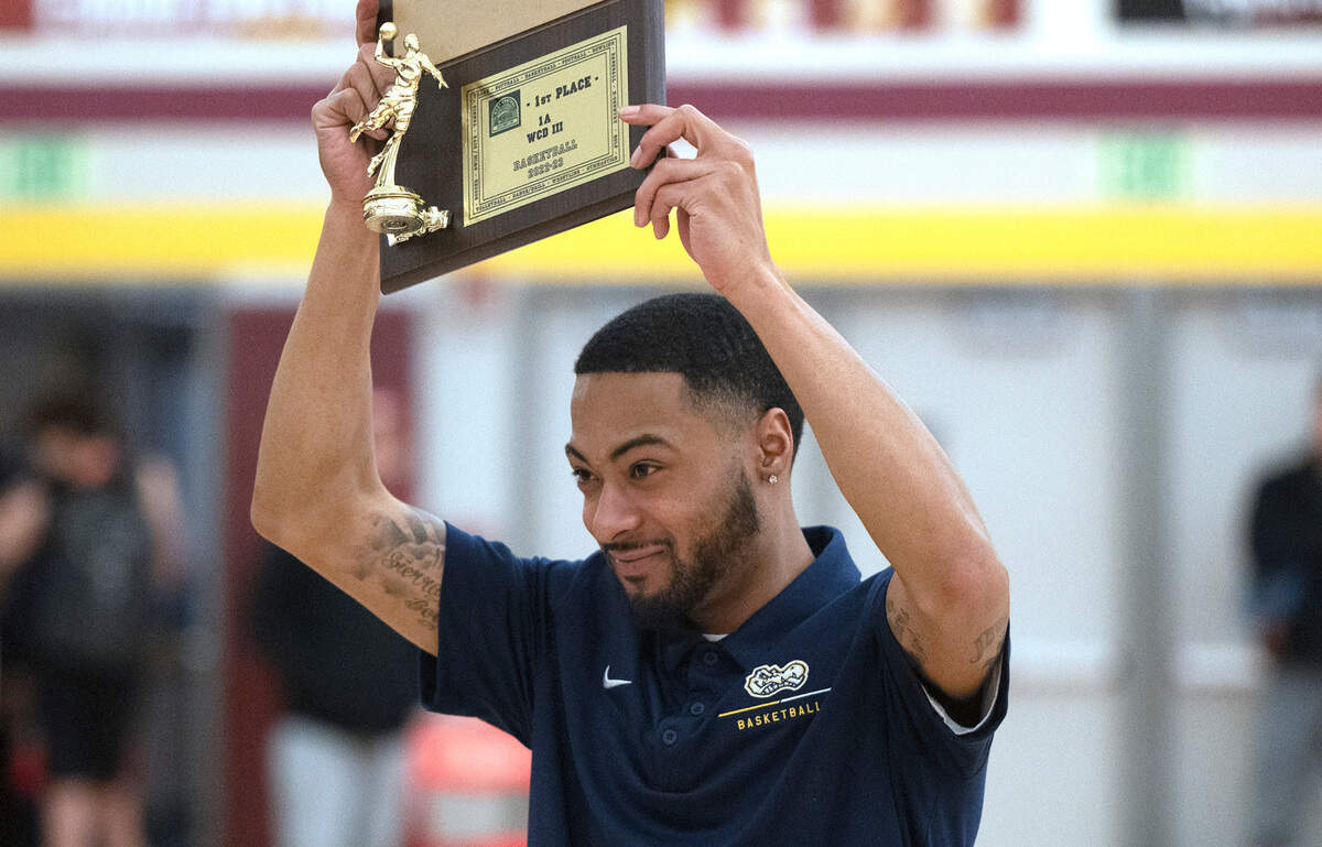 Annie Wright boys basketball head coach Dominique Williams hoists the championship trophy after the Gators defeated the Seattle Christian Warriors, 65-60, in the 1A West Central District boys basketball championship game at Mount Tahoma High School in Tacoma, Washington, on Wednesday, Feb. 15, 2023.