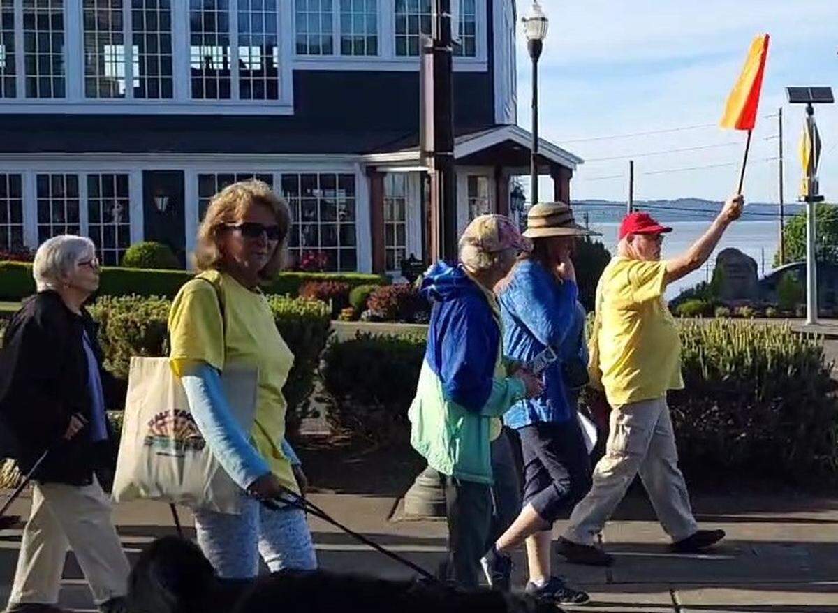Downtown on the Go volunteer Steven Bird (with flag, far right) assists with a walking tour in Old Town Tacoma, date unknown. He died in December 2024 after he was assaulted in a Burien crosswalk.