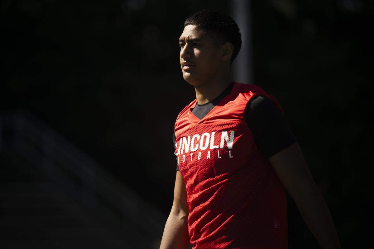 Lincoln quarterback Sione Kaho warms up during a football practice at Lincoln High School on Wednesday, Aug. 20, 2025, in Tacoma, Wash..