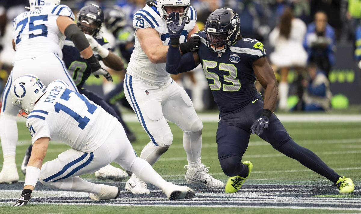 Indianapolis Colts quarterback Philip Rivers (17) falls as Seattle Seahawks linebacker Boye Mafe (53) pressures him during the second quarter of the game at Lumen Field, on Sunday, Dec. 14, 2025, in Seattle.