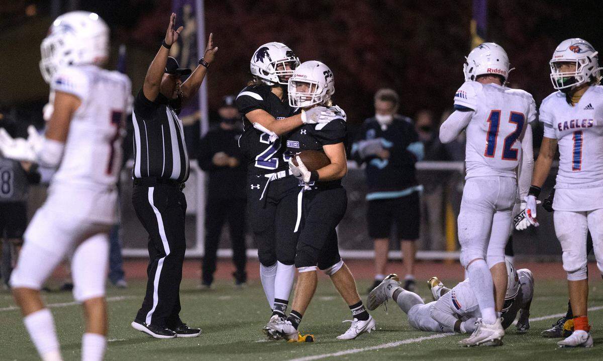 Sumner running back Matthew Spurbeck (right) is congratulated by teammate Jay Mentick following his touchdown run during Saturday night’s 4A SPSL high school football game against the Graham-Kapowsin Eagles at Sunset Chev Stadium in Sumner, Washington, on Oct. 16, 2021.