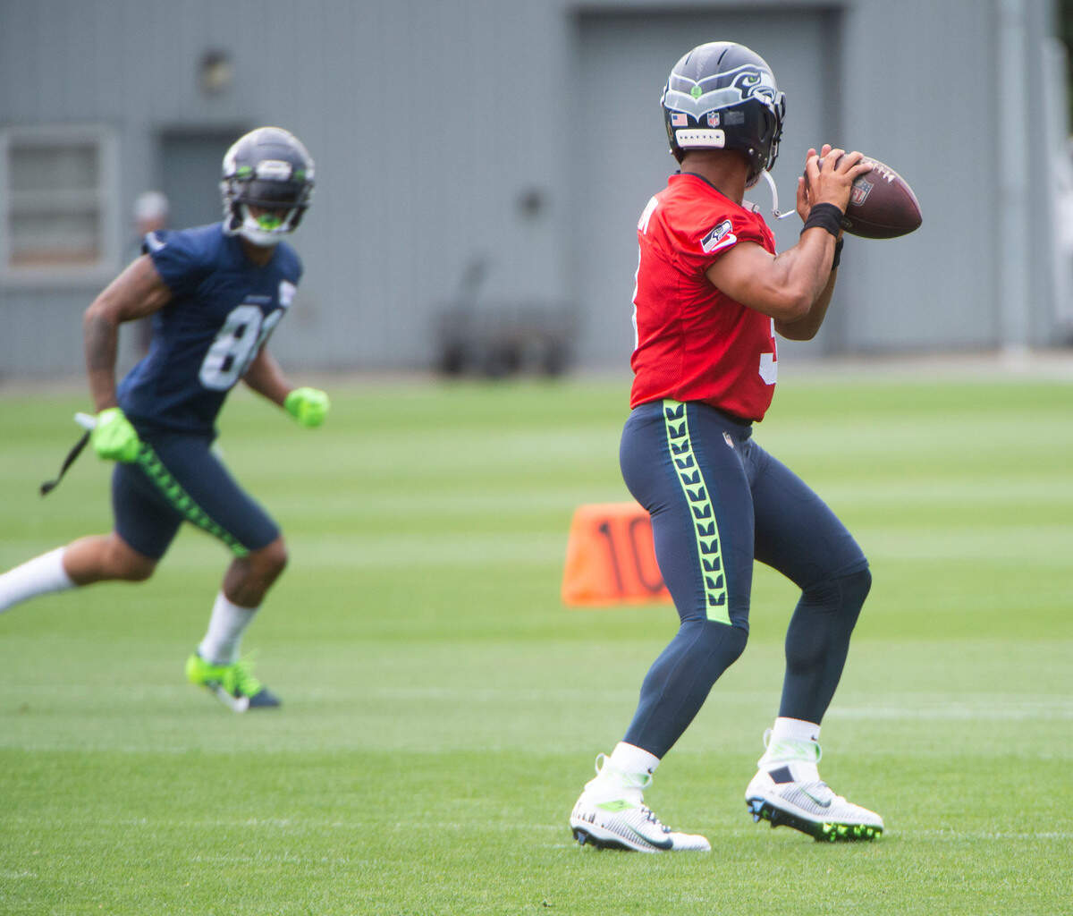 Seattle quarterback Russell Wilson looks downfield for new tight end Gerald Everett during the fourth day of Seahawks training camp Saturday, July 31, 2021 at the VMAC in Renton.