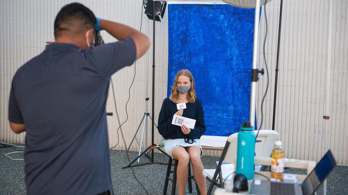 Lana Levi, an incoming ninth-grader, wears a mask as she gets an identification photo taken at Gig Harbor High School in Gig Harbor, Wash., on Friday, Sept. 4, 2020.
