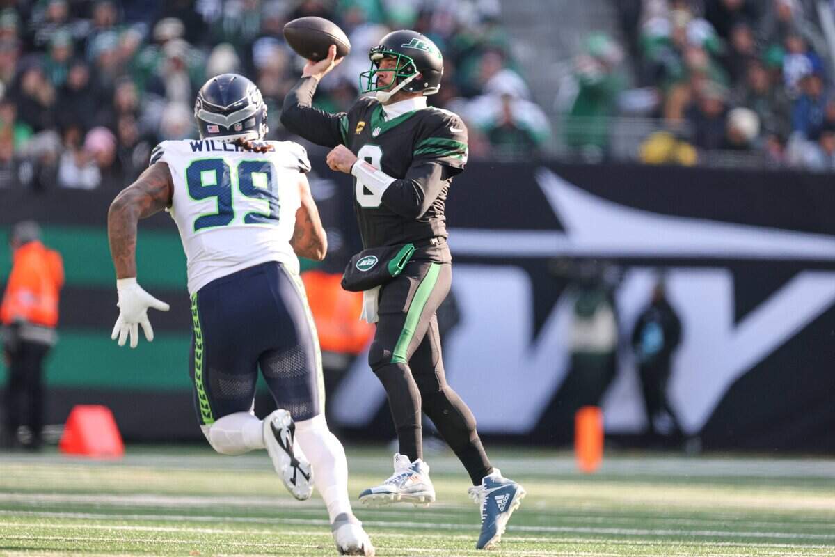 Seattle Seahawks cornerback Coby Bryant (8) throws the ball as Seattle Seahawks defensive end Leonard Williams (99) pursues during the first quarter at MetLife Stadium. Mandatory Credit: Vincent Carchietta-Imagn Images