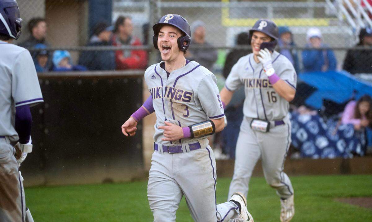 Puyallup’s Tristan Ringrose (3) and Kai Halstead celebrate after scoring on a two-run double by teammate Mason Pike during Wednesday afternoon’s baseball game against the Olympia Bears at Olympia High School in Olympia, Washington, on April 12, 2023. Puyallup won the game, 6-2.