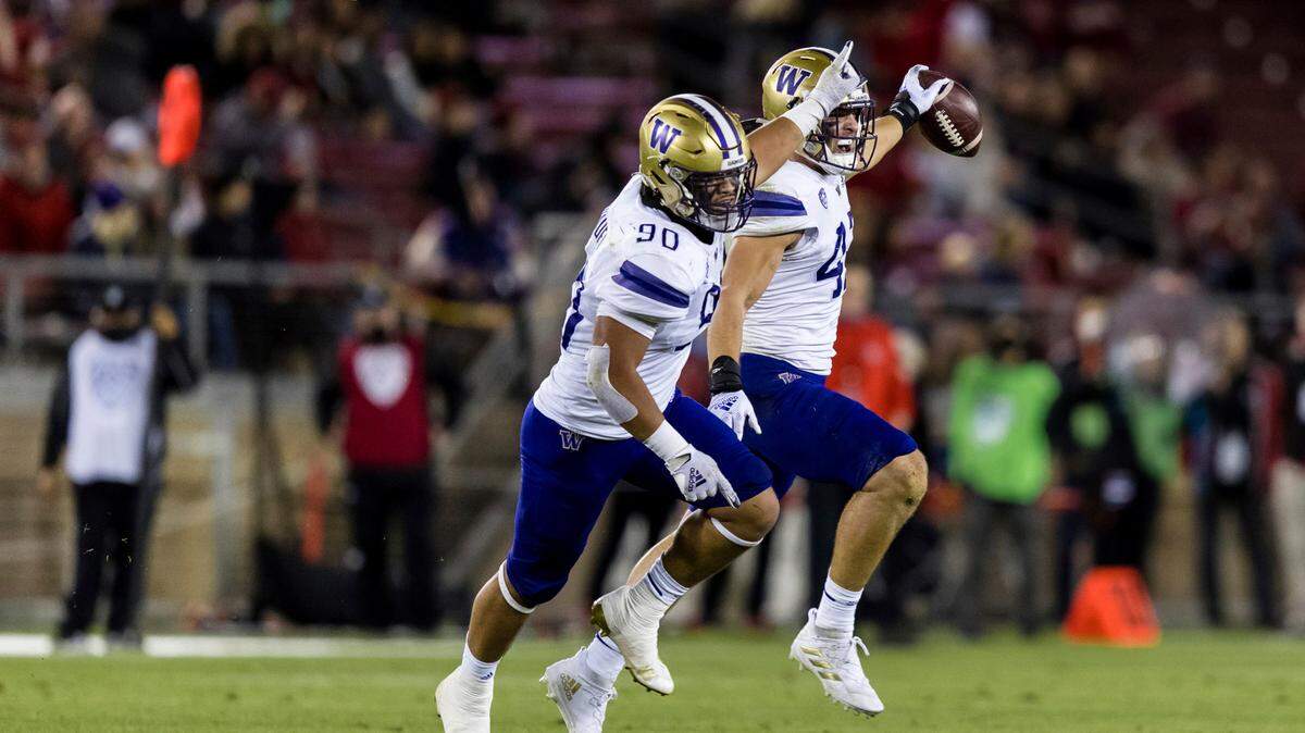Washington linebacker Jackson Sirmon, back, celebrates with lineman Voi Tunuufi (90) after intercepting a pass by Stanford during the second quarter of an NCAA college football game in Stanford, Calif., Saturday, Oct. 30, 2021. (AP Photo/John Hefti)