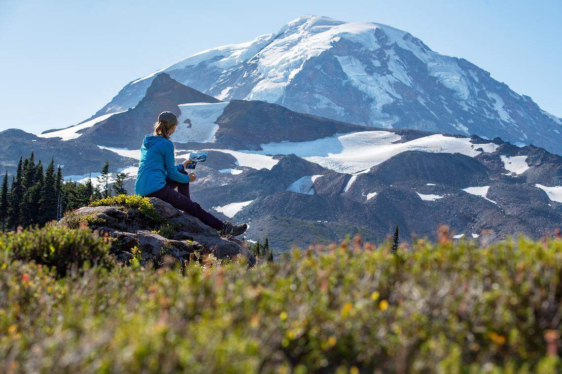 Environmental artist Claire Giordano is pictured painting a view of Mount Rainier’s glaciers.