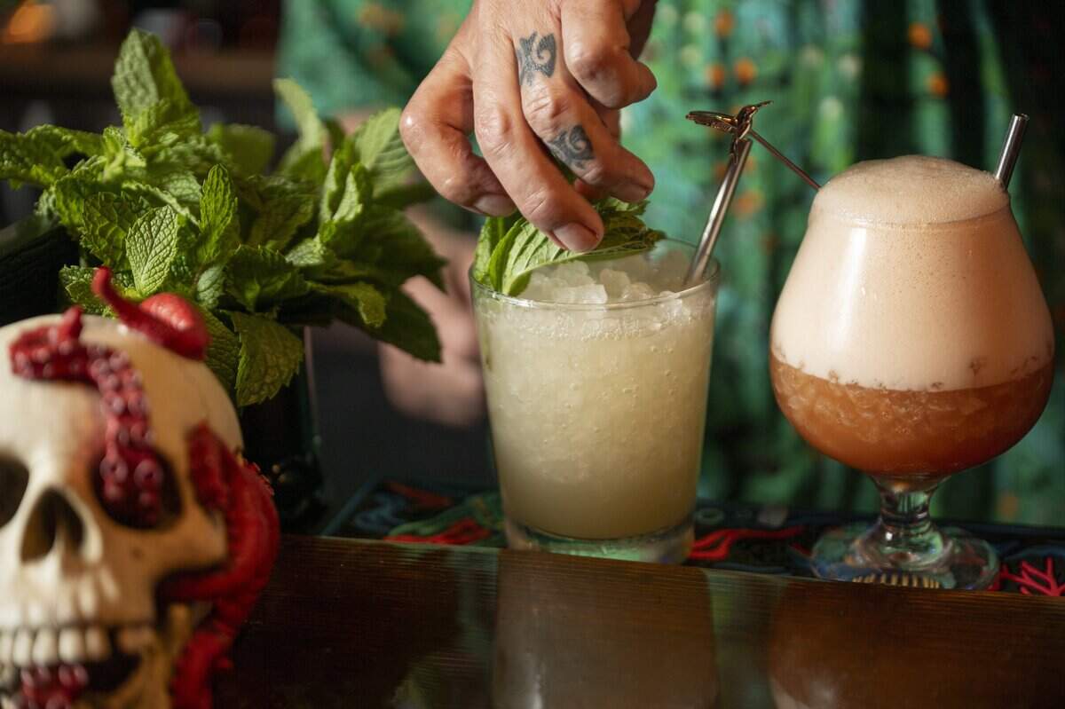 Bartender Rob Canavan garnishes a classic Mai Tai, left, and Jungle Bird at Da Tiki Hut on Thursday, July 9, 2026, in Tacoma, Wash.