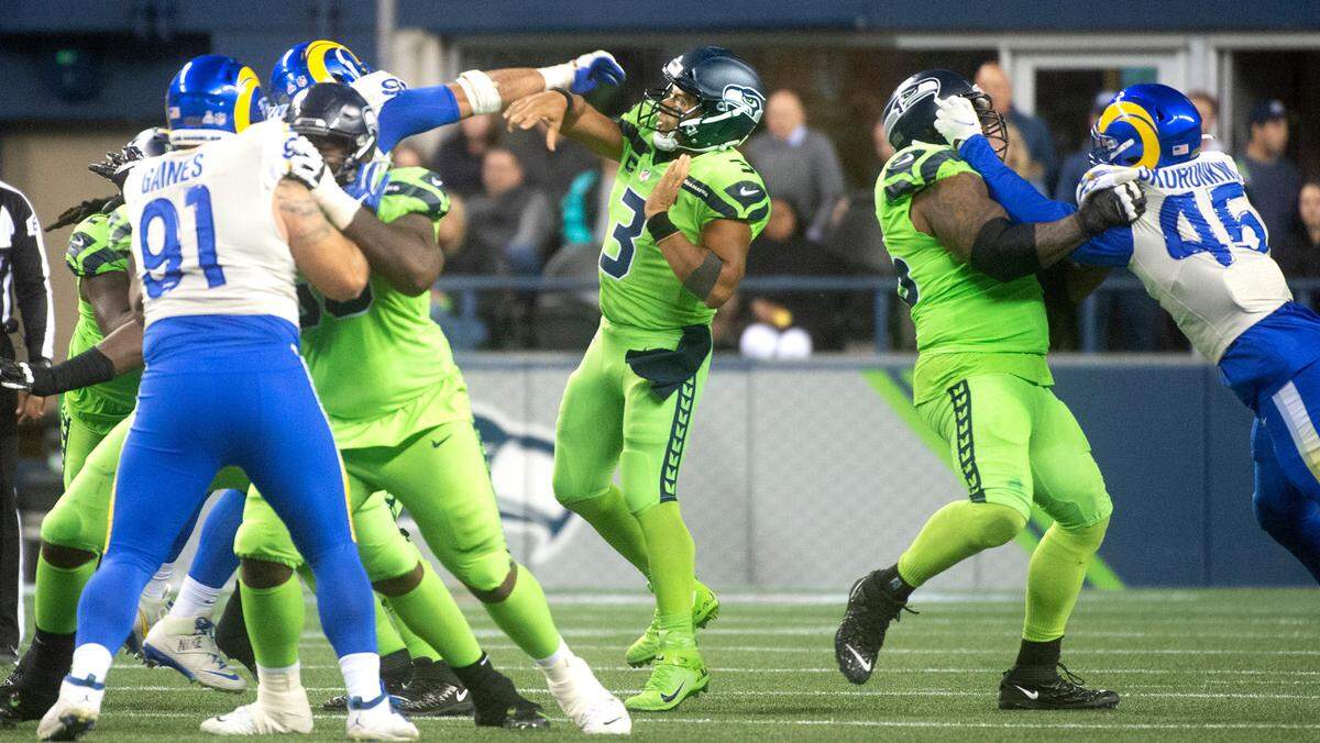 Seattle Seahawks quarterback Russell Wilson fires a pass under pressure from the Los Angeles Rams defense during the NFL’s Thursday Night Football game against the Los Angeles Rams at Lumen Field in Seattle, Washington, on Oct. 7, 2021. The Rams won the game, 26-17.