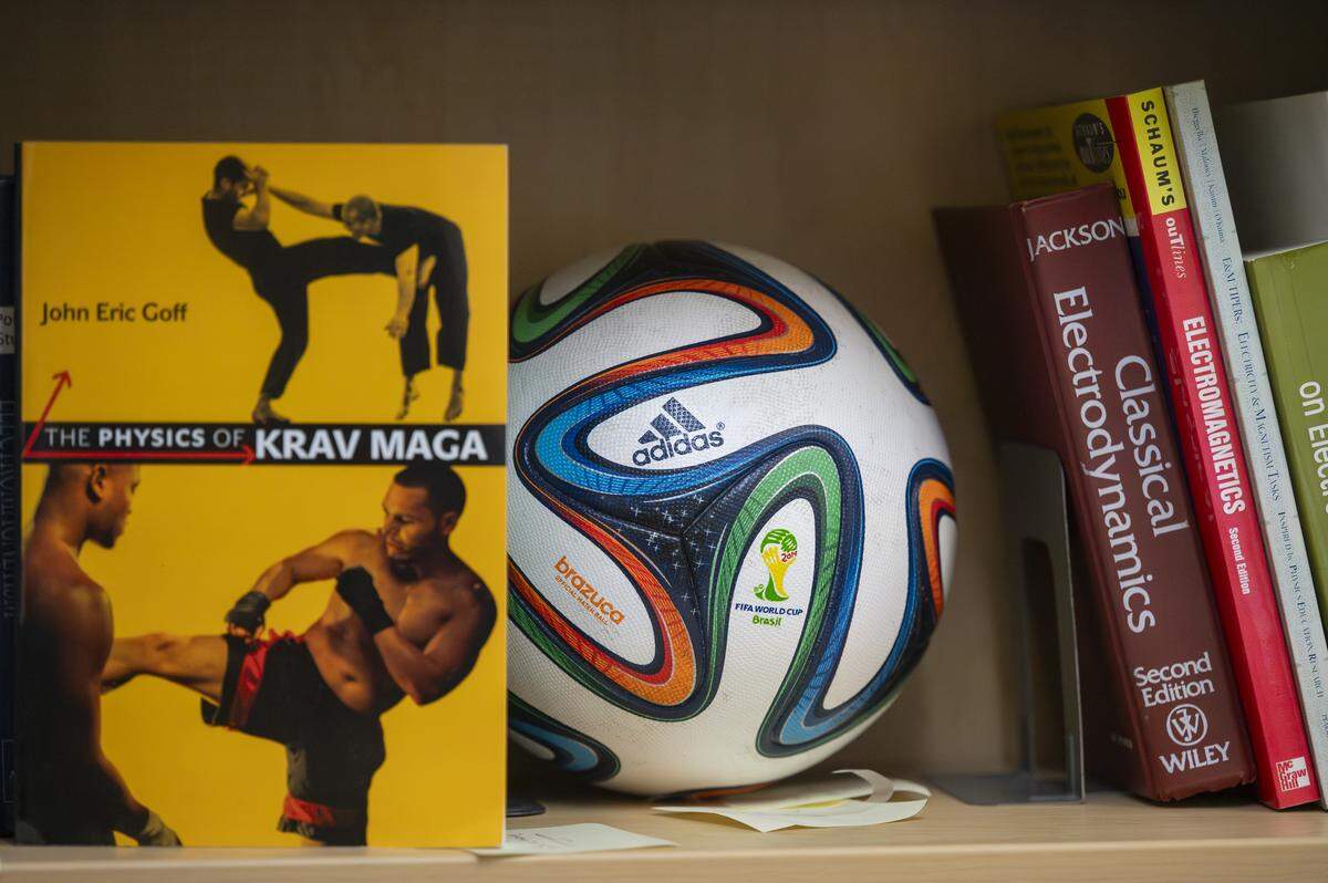 Research books, including one written by Professor John Eric Goff on sports physics, sit on a shelf by a previous FIFA World Cup ball studied for its aerodynamics by Goff, in his office on Wednesday, Oct. 29, 2025, at the University of Puget Sound in Tacoma, Wash. 