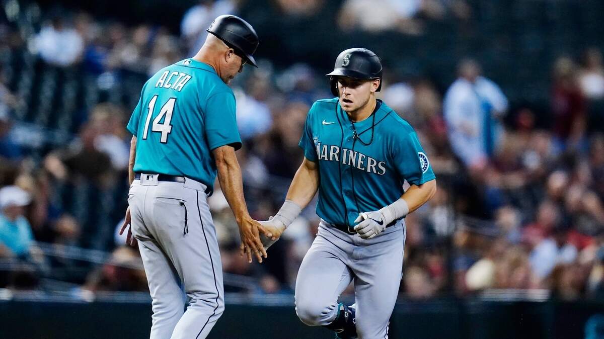Seattle Mariners’ Jarred Kelenic, right, celebrates his two-run home run against the Arizona Diamondbacks with Mariners third base coach Manny Acta (14) during the sixth inning of a baseball game Friday, Sept. 3, 2021, in Phoenix. (AP Photo/Ross D. Franklin)