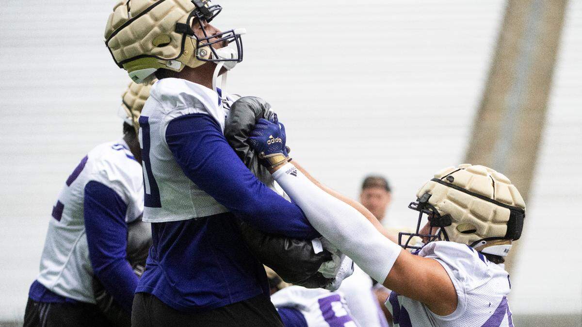 University of Washington Huskies edge Zion Tupuola-Fetui, 58, holds a pad to his chest as Huskies edge Maurice Heims, 45, shoves him during a drill at the first day of Fall practice at Husky Stadium on Thursday, Aug. 4, 2022 in Seattle, Wash.