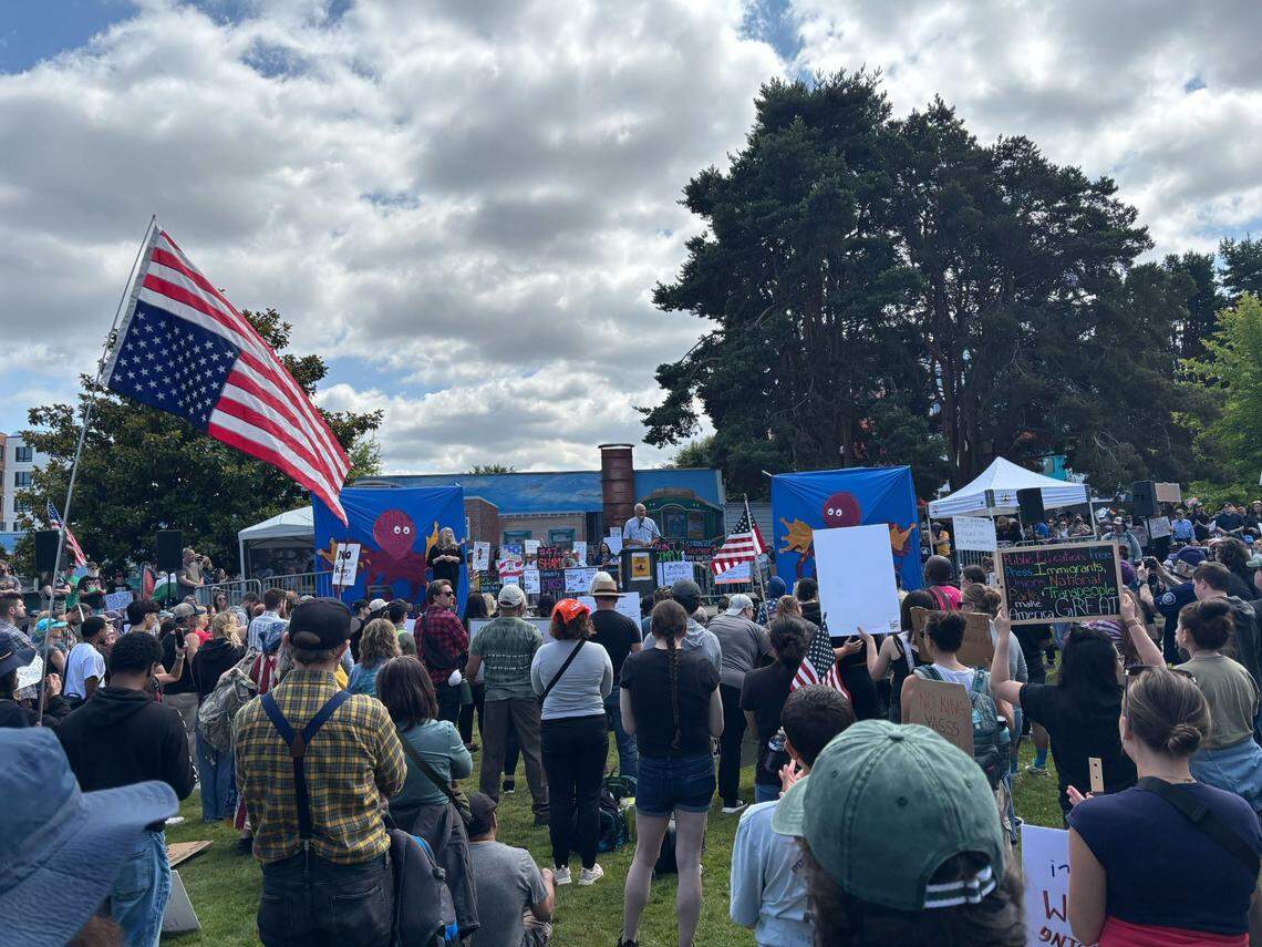Fomer Washington Gov. Jay Inslee (center, light blue shirt) joins the No Kings gathering at People’s Park in Tacoma on Saturday, June 14, 2025.