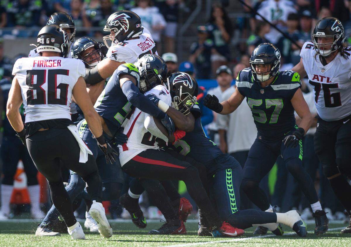 Seattle Seahawks linebacker Jordyn Brooks (56) and Seattle Seahawks linebacker Boye Mafe (53) tackle Atlanta Falcons running back Cordarrelle Patterson (84) in the second quarter of an NFL game at Lumen Field in Seattle, Wash. on Sept. 25, 2022.
