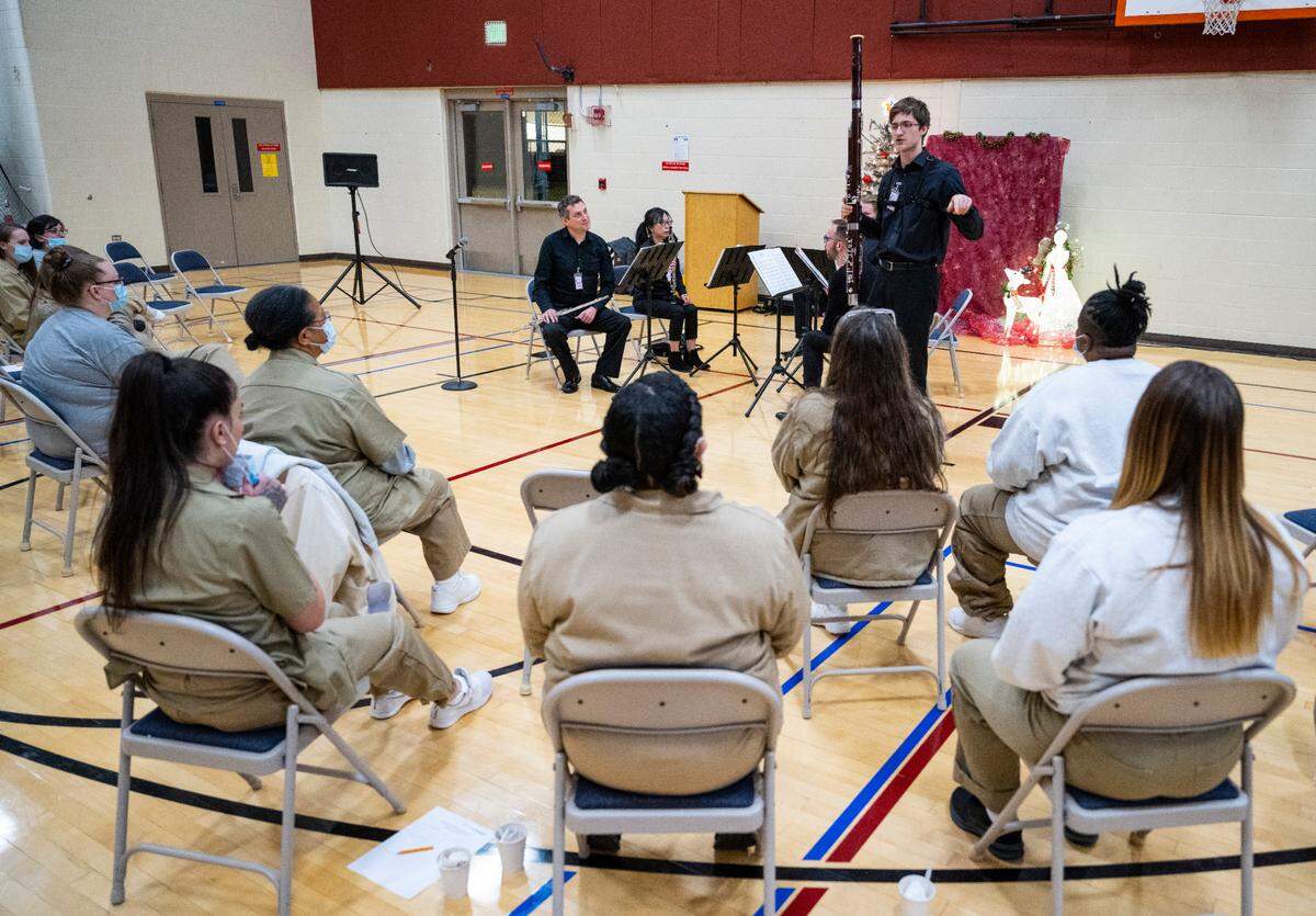 Seattle Symphony member Kirpas Mazeika describes how to play the bassoon to inmates at the Washington Corrections Center for Women while performing with other members of the Seattle Symphony in the center’s gymnasium in Gig Harbor, Wash. on Dec. 6, 2022.