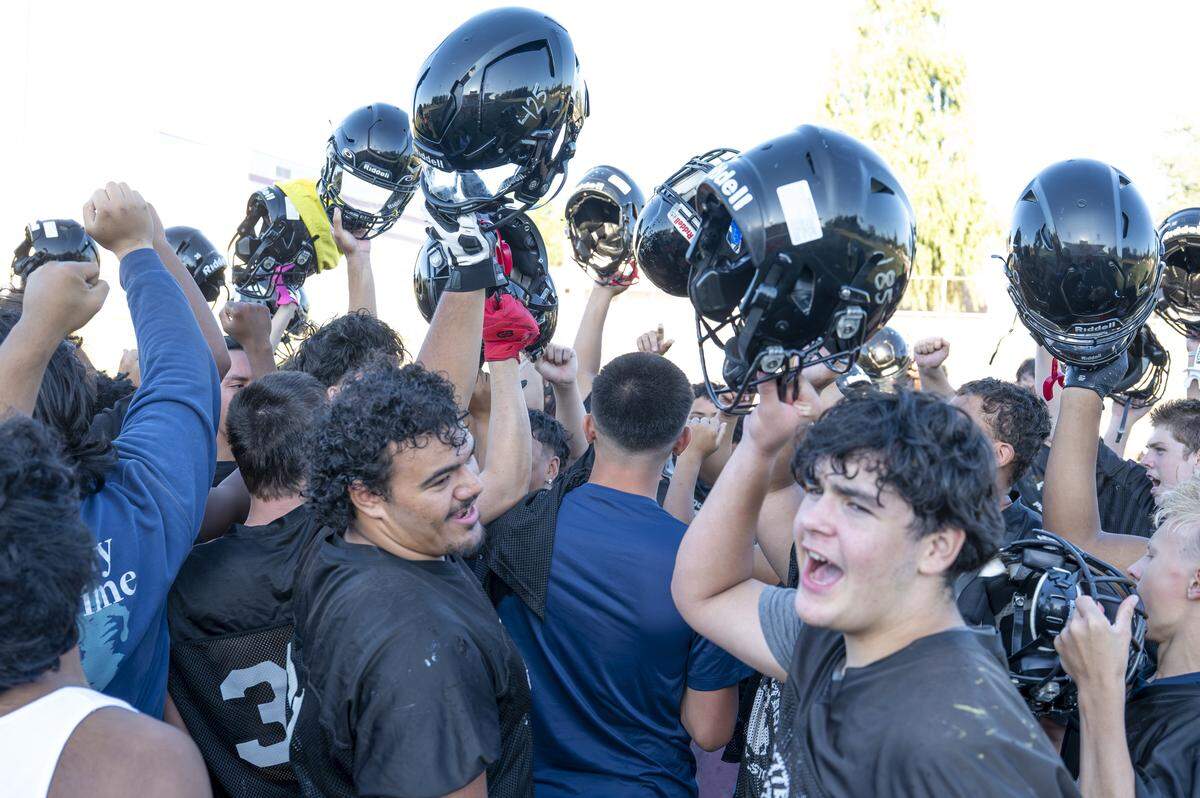Franklin Pierce players raise their helmets and cheer to end their practice on Wednesday, Aug. 20, 2025, in Tacoma, Wash.