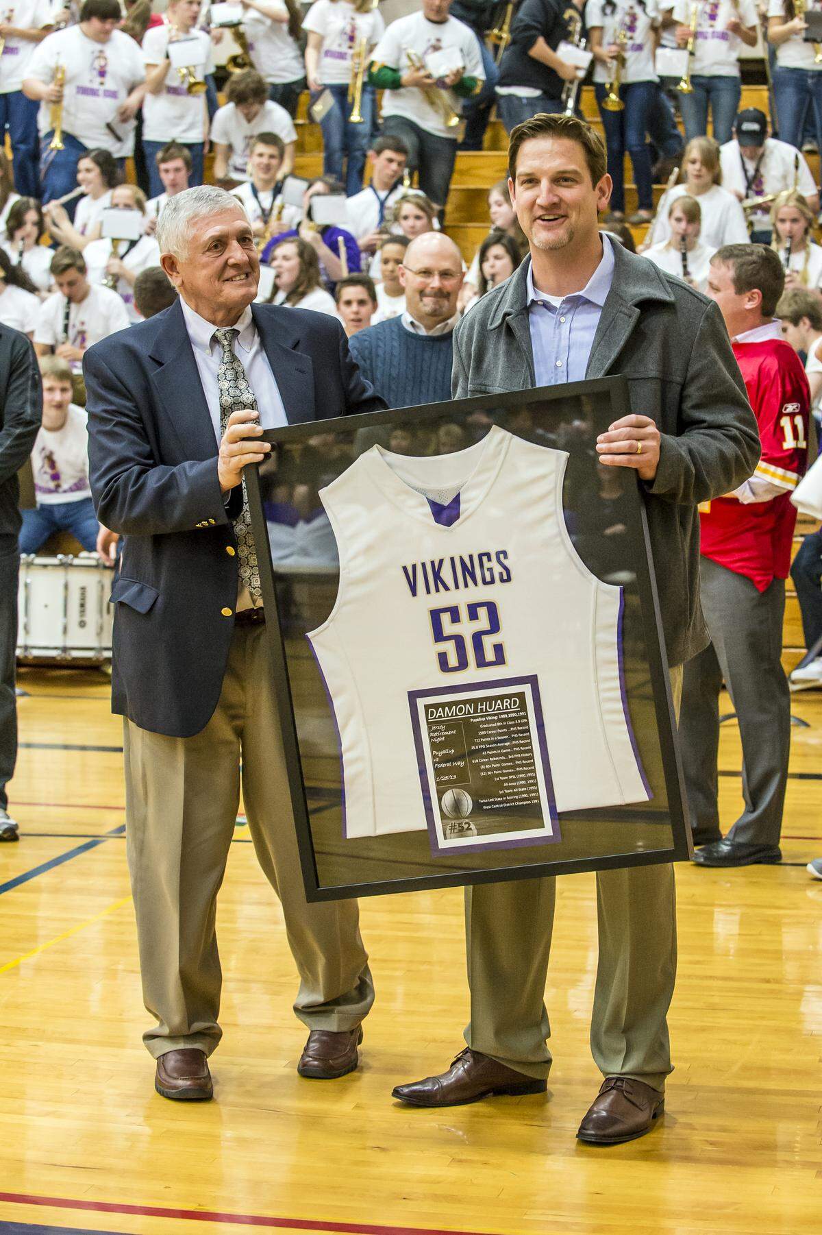 Damon Huard, right, and former Vikings boys basketball head coach Jim Cliton, left, share a moment together as Huard’s basketball jersey was retired in front of the hometown fans. KENT NEWMAN/Special to the Herald