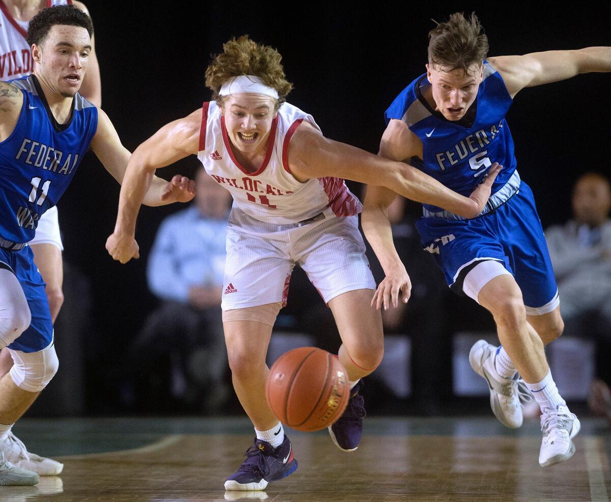 Mount Si’s Bennett O’connor (center) races Federal Way defenders Jaden Call (left) and Bradley Graham to a loose ball during Thursday night’s quarterfinal game of the WIAA 4A boys state basketball tournament in the Tacoma Dome on March 5, 2020.