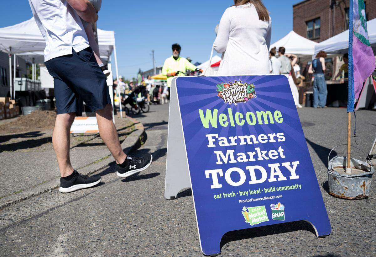 People peruse vendors ranging from produce, baked goods food at the Proctors Farmers Market, on Saturday, May 11, 2024, in Tacoma, Wash.
