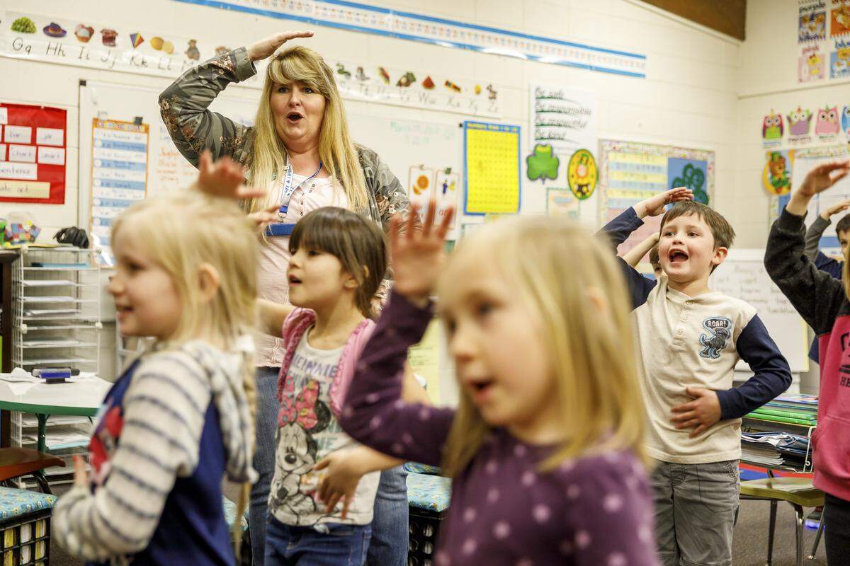 First-grade teacher Tiffany Bonney uses a video program to help her students exercise because Evergreen Elementary School is unable to fund a PE teacher, in Cave Junction, Ore., March 22, 2018. Oregon is facing a severe, self-inflicted crisis as mounting pension obligations crowd out the rest of its budgets.