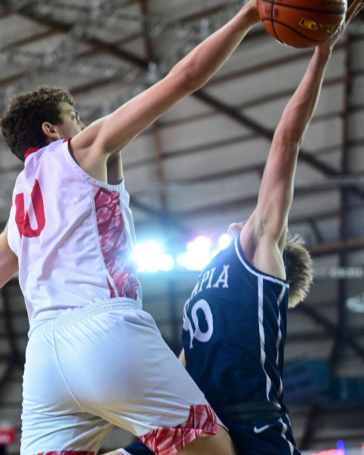 Olympia guard Drew Carlson (10) has his shot blocked by Mount Si forward Miles Heide (40) during the fourth quarter of a Class 4A semifinal state tournament game on Friday, March 4, 2022, at the Tacoma Dome, in Tacoma, Wash.