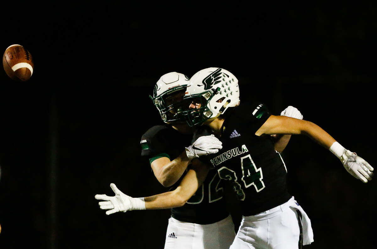 Peninsula’s Landon Sims and Chris Akulschin celebrate a touchdown catch by Chris Akulschin during the third quarter.Peninsula played Yelm in a football game at Roy Anderson Field in Purdy, Wash., on Friday, Oct. 18, 2019.