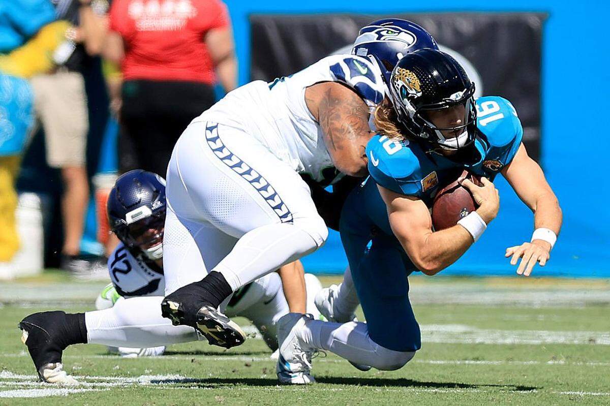 JACKSONVILLE, FLORIDA - OCTOBER 12: Trevor Lawrence #16 of the Jacksonville Jaguars is tackled by Byron Murphy II #91 of the Seattle Seahawks during the first quarter in the game at EverBank Stadium on October 12, 2025 in Jacksonville, Florida. (Photo by Mike Carlson/Getty Images)