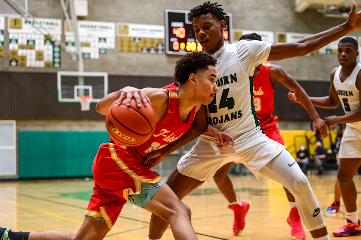 Mount Tahoma guard Asjon Anderson (20) dribbles toward the basket as Auburn guard Dae’Kwon Watson (24) defends during the third quarter of a non-league game on Thursday, Jan. 20, 2022, at Auburn High School.