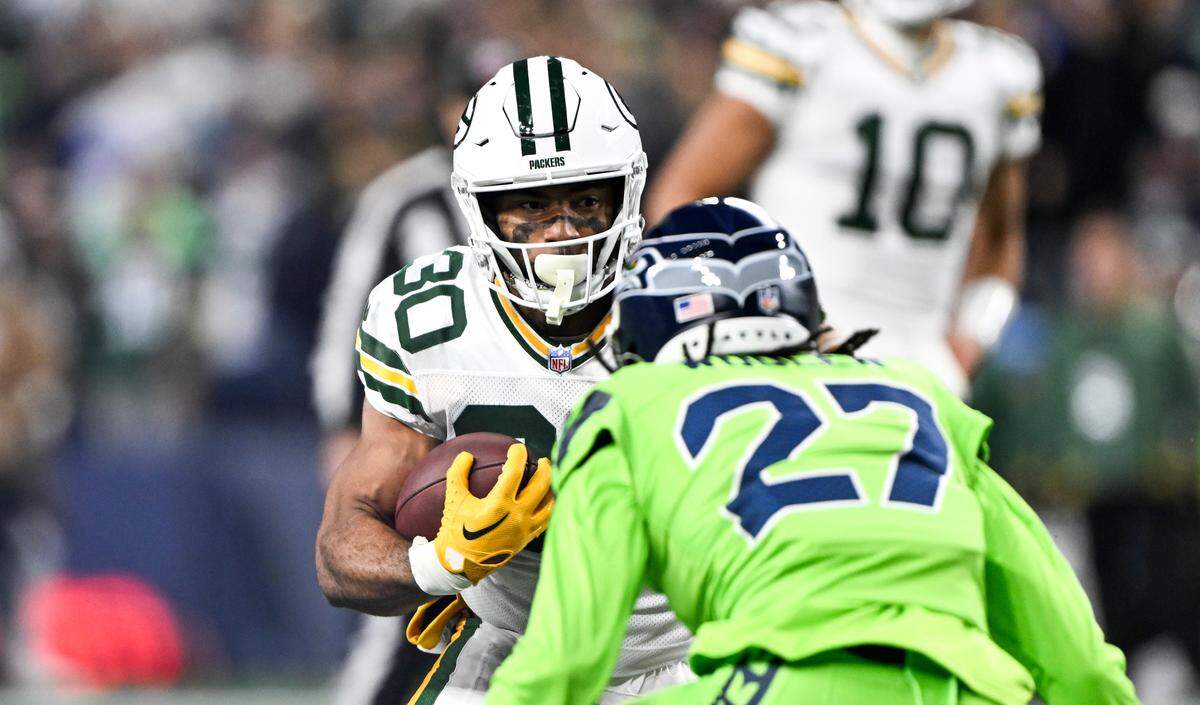 Green Bay Packers running back Chris Brooks (30) looks to juke Seattle Seahawks cornerback Riq Woolen (27) during the first quarter of the game at Lumen Field, on Sunday, Dec. 15, 2024, in Seattle, Wash.