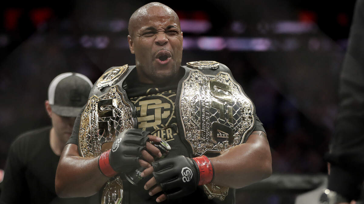 Daniel Cormier holds his belts after defeating Derrick Lewis by submission during the second round of a heavyweight mixed martial arts bout at UFC 230, early Sunday, Nov. 4, 2018, at Madison Square Garden in New York. (AP Photo/Julio Cortez)