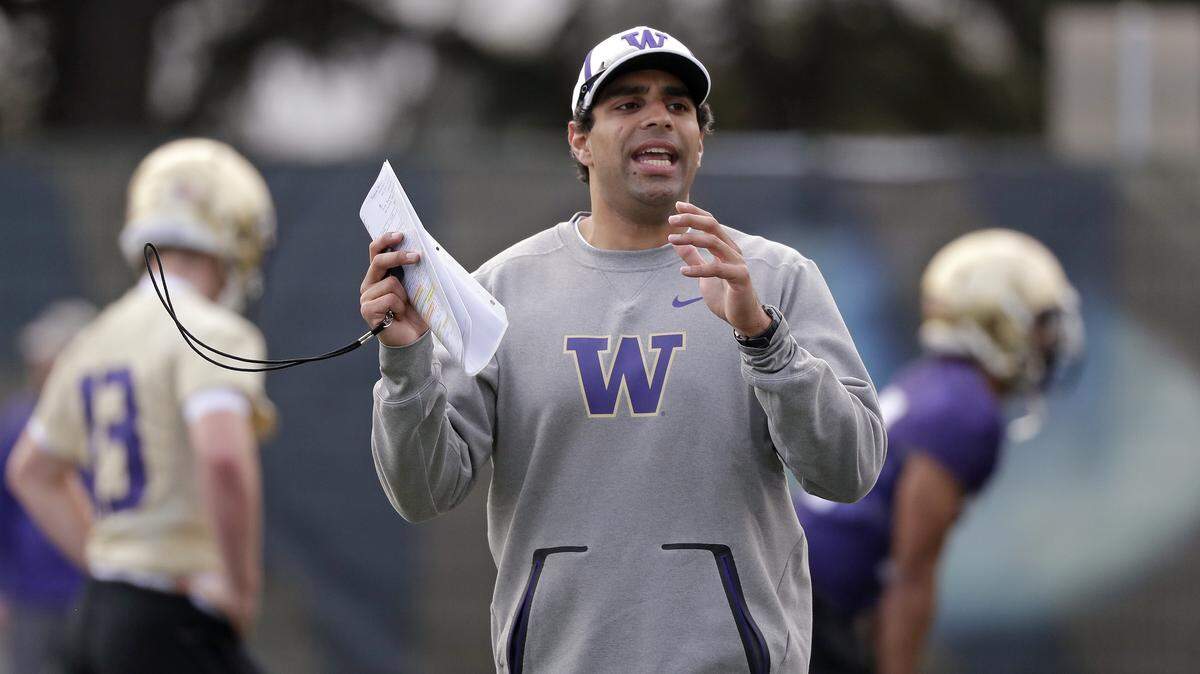 Washington offensive coordinator Bush Hamdan works with players at the first practice of spring football for the NCAA college team Wednesday, March 28, 2018, in Seattle. (AP Photo/Elaine Thompson)nam