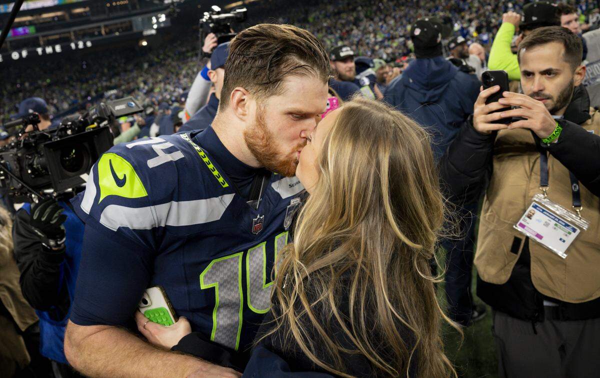 Seattle Seahawks quarterback Sam Darnold (14) and partner Katie Hoofnagle kiss after the Seattle Seahawks win the NFC Championship against the Los Angeles Rams at Lumen Field, on Sunday, Jan. 25, 2026, in Seattle.