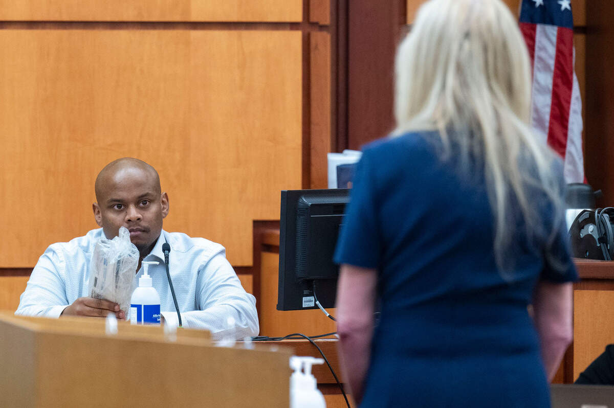 Sedrick Altheimer holds up the copy of the Tacoma News Tribune that he delivered to Pierce County Sheriff Ed Troyer’s home after they had an incident on Jan. 27, 2021, during cross examination on Tuesday, Dec. 6, 2022, in Pierce County District Court in Tacoma, Wash.