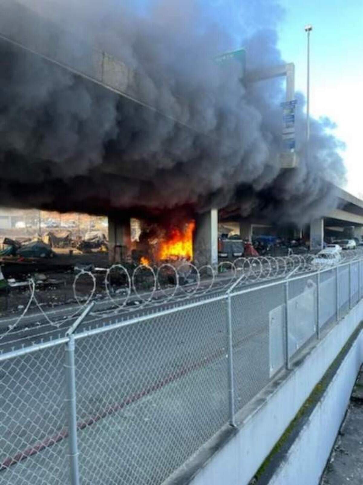 A fire breaks out at a homeless encampment beneath I-705 in Tacoma on Jan. 27, 2022. Multiple fires at the site led to the city to decide to clear the camp.