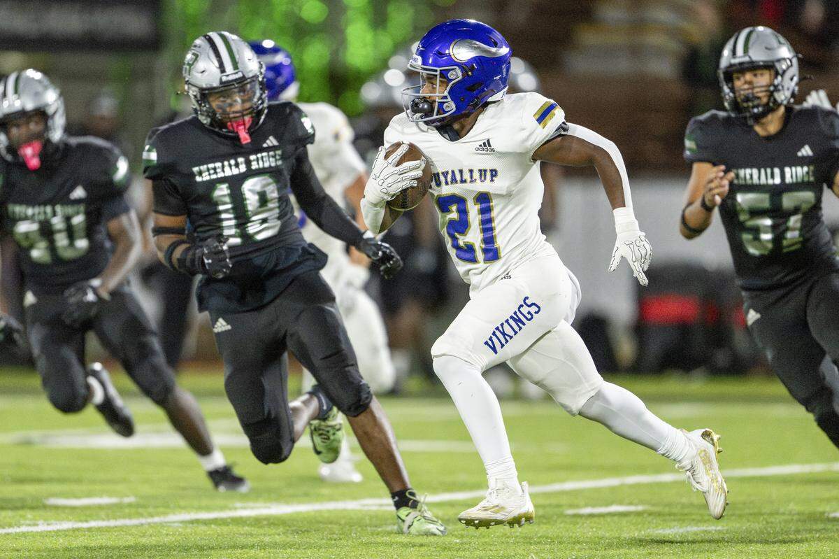 Puyallup’s Briytan Bailey (21) carries the ball down the field with pressure from Emerald Ridge defenders on Friday, Sept. 26, 2025, in Puyallup, Wash.