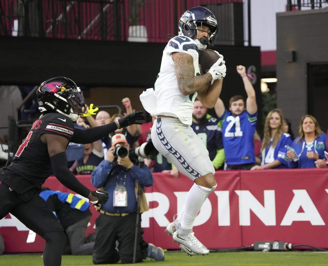 Seattle Seahawks wide receiver Jaxon Smith-Njigba (11) catches a touchdown against Arizona Cardinals cornerback Garrett Williams (21) during the first quarter at State Farm Stadium in Glendale on Dec. 8, 2024.