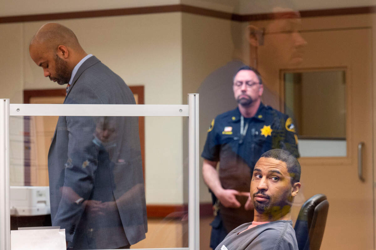 Andrew Pointer looks over his shoulder after being sentenced as his attorney Myles Julian Johnson looks over paper work as the victim’s brother Steven Pimentel is seen in the reflection of the courtroom windows staring at Pointer during his sentencing hearing on Friday, April 22, 2022, in Tacoma, Wash. On Friday, Pointer was sentenced to 40 years in prison for the first-degree murder of 38-year-old Lawrence Andre Jeffries in 2019.
