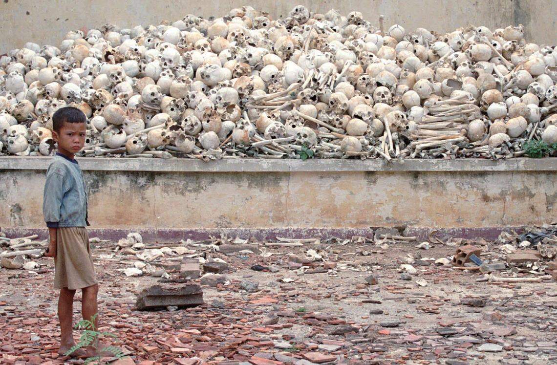 A Cambodian boy stands infront of a platform covered with human skulls at a killing field in Trapeang Sva Village, Kandal province, 15 miles south of Phnom Penh in 1995. The mass grave contains the remains of about 2,000 victims of the Khmer Rouge who slaughtered nearly a million Cambodians during their brutal reign from 1975-1978.